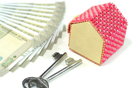 Concept of real estate market in India. Indian currency with a model house and keysの写真素材
