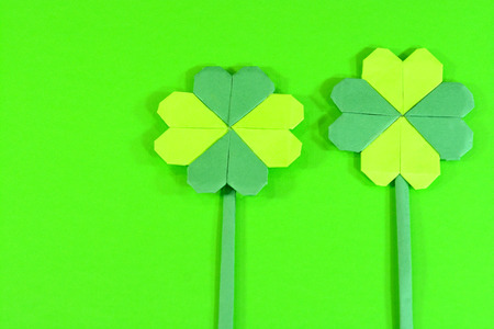 Origami clover flowers on a green background.の写真素材