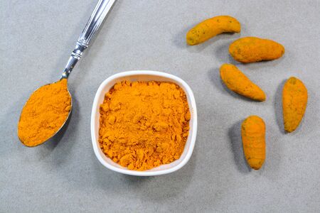 Closeup view of turmeric and turmeric powder in a bowlの写真素材