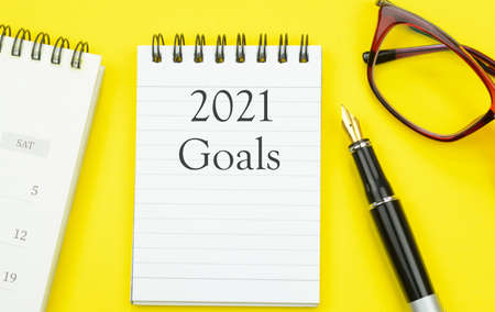 2021 goals written on a notepad with yellow backgroundの写真素材