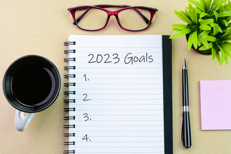 2023 goals text written on a notebook with pen and coffee cupの写真素材