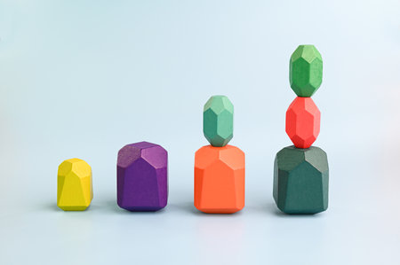 Concept of growth. Multicolored wooden blocks arranged on a blue backgroundの写真素材