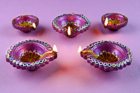 Indian festival Diwali, Diya oil lamps lit on colorful rangoli. Hindu traditional. Happy Deepavali. Copy space for text.の写真素材