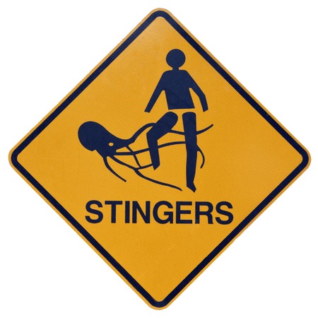 A yellow and black warning sign for dangerous marine stingers or jellyfish in tropical Australia.の写真素材