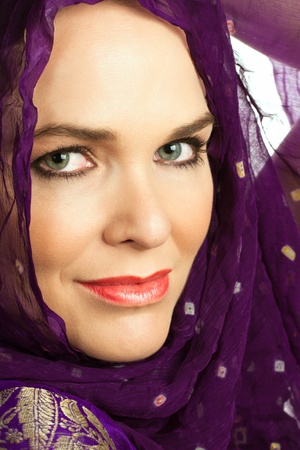 Closeup portrait of a beautiful Indian woman wearing a head scarf and looking at the cameraの写真素材