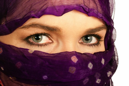 A closeup of a very beautiful Indian or asian woman wearing a purple veilの写真素材