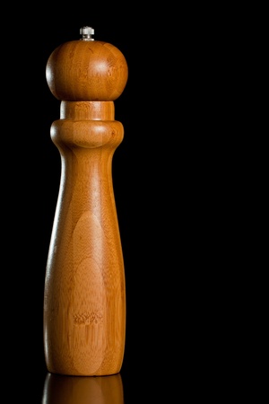 Wooden salt or pepper grinder isolated over blackの写真素材