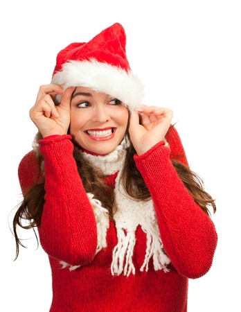 An attractive young woman smiling and peeking out from a santa hat. Isolated on white.の写真素材