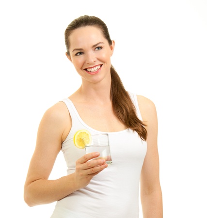 Isolated portrait of a young beautiful fresh woman holding a glass of water with slice of lemon.の写真素材