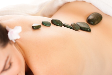 Fit young woman getting a relaxing hot stone massageの写真素材