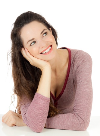 An attractive young woman smiling and looking at copyspace. Isolated on white.の写真素材
