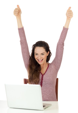 Isolated portrait of a very happy beautiful woman looking at laptop and doing thumbs upの写真素材