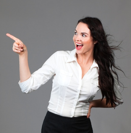 Beautiful young smiling business woman pointing to copyspaceの写真素材