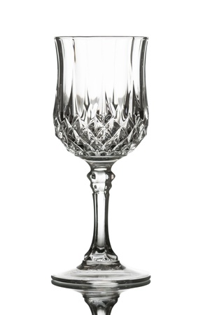 An empty red wine glass on a reflective table. Isolated on white.の写真素材