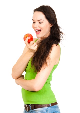 A beautiful young woman holding and looking at an apple. Isolated on whiteの写真素材