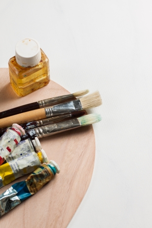 Oil paints, paint brushes and solvent on a pallette and blank canvasの写真素材
