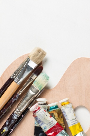 Oil paints and paint brushes on a  blank canvasの写真素材