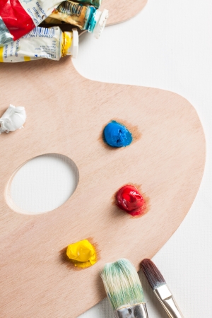 Oil paint, paint tubes and paint brushes on a wooden palletteの写真素材