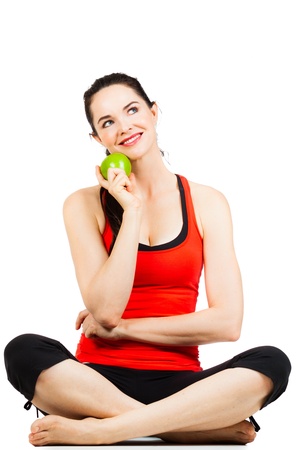 A happy young sporty and healthy woman holding an apple and looking at copyspaceの写真素材