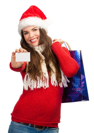 A beautiful woman wearing a Christmas hat and holding shopping bags and a blank business card.の写真素材