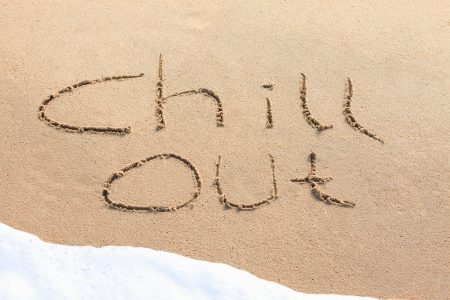 Chill out - written in the sand with a foamy wave underneathの写真素材