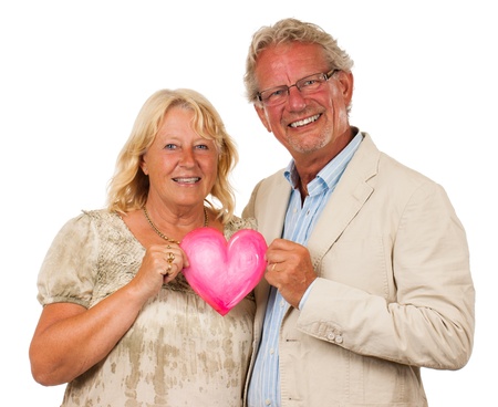 A happy middle aged couple holding a love heart and smiling,  Isolated on white の写真素材