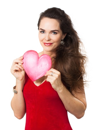 A beautiful young woman in a red dress holding a red love heart  Isolated on white の写真素材