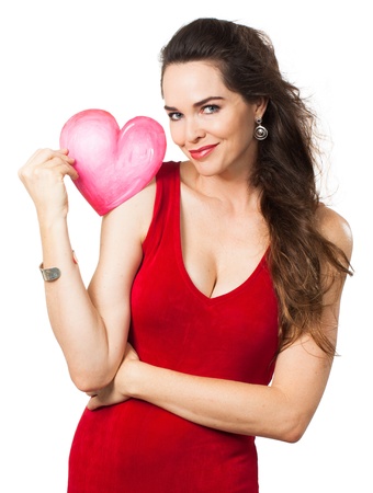 A beautiful seductive young woman in a red dress holding a red love heart  Isolated on white の写真素材