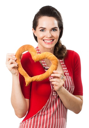 Portrait of  beautiful happy woman wearing an apron and holding  a love heart made out of bread  Isolated on white の写真素材