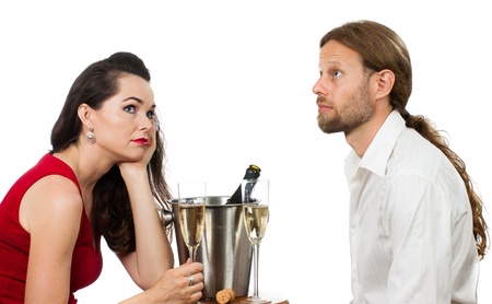A bored couple out on a Champagne date avoiding eye contact  Isolated on white の写真素材
