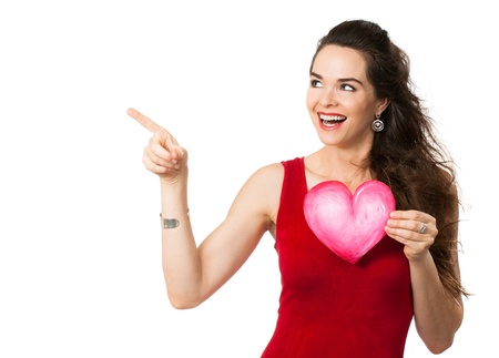 Happy beautiful woman holding a love heart and pointing at copy-space  Isolated on white の写真素材