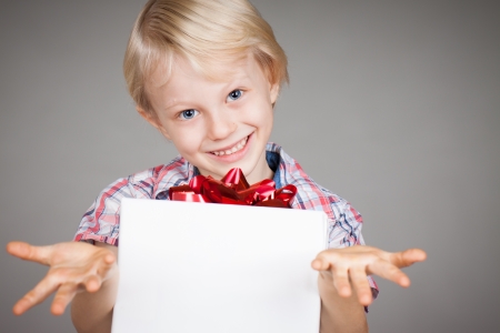 A very cute young boy giving a present and smiling at camera の写真素材