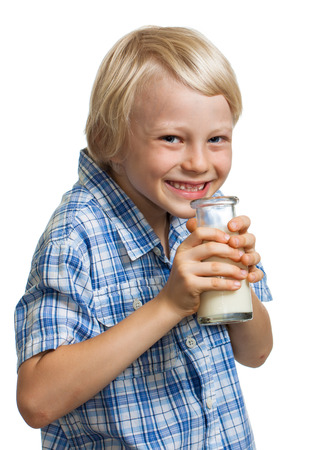 Happy cute boy giggling and holding a bottle of milk to his mouth  Isolated on white の写真素材