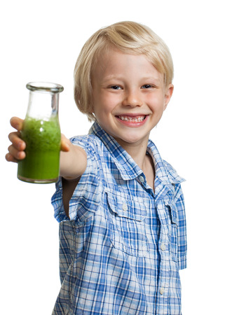A happy smiling boy holding out a bottle of green smoothie or juice  Isolated on white の写真素材