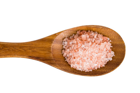 Close-up of pink Himalayan rock-salt on a wooden spoon. Isolated on white.の写真素材