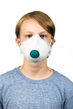 Young teenage boy wearing a protective mask to protect against virus infection.  Isolated on white.の写真素材