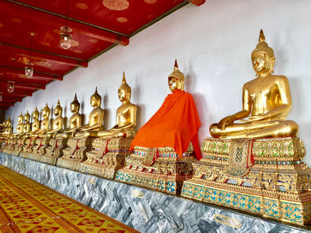 One gold statue among many is covered in an orange blanketのeditorial素材