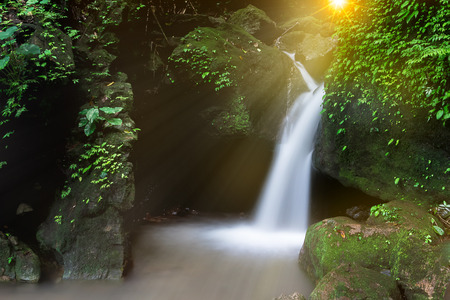 Waterfall streams flowing over a large chunk of rock has many ravines and MOSS.Thailandの写真素材