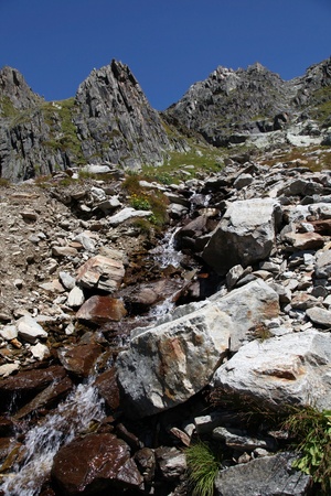Small river crossing the path to the refuge of Albert1er near the Chardonnay peakの写真素材