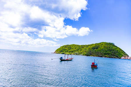 fisher boat in front of a green island at koh samui in thailand