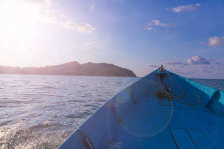 fisher boat in front of a green island at koh samui in thailand