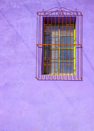 Painted Purple Stucco Wall with Barred Window and Shadow