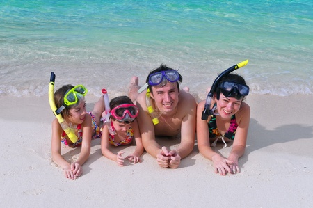 Family in snorkels on tropical beach の写真素材