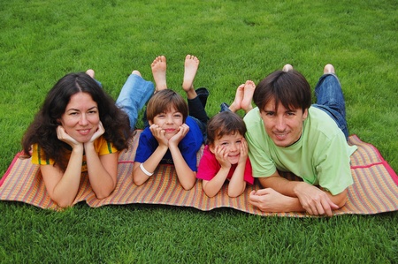 Family with two kids on the grassの写真素材
