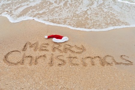 Holiday background - Merry Christmas written on tropical beach sandの写真素材