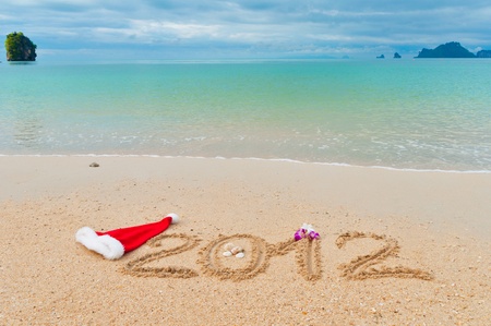 Numbers 2012 and santa hat on tropical beach sand - holiday backgroundの写真素材