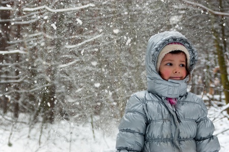Happy child having fun in winter forest. Little girl outdoorsの写真素材