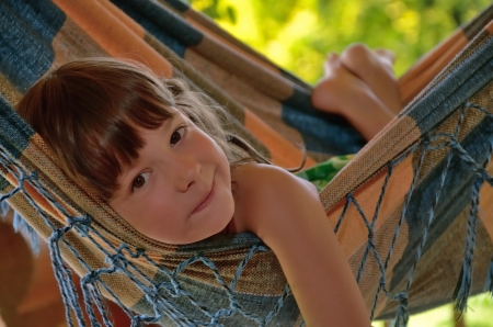 Little happy girl relaxing in hammock  Smiling kid on family summer vacationの写真素材
