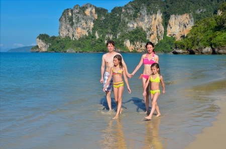 Happy family on tropical beach having fun on vacationの写真素材