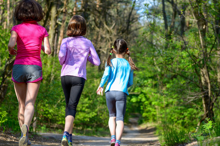 Family sport happy active mother and kids jogging outdoors running in forestの写真素材
